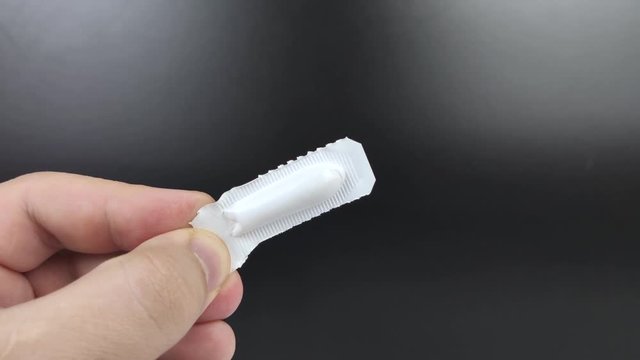 Suppositories in white packaging in the hands of a man. Macro video of rectal or vaginal suppositories before use.