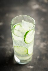 Detox beverage with cucumber slices on the rustic background. Selective focus. Shallow depth of field.