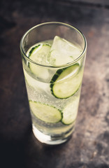 Detox beverage with cucumber slices on the rustic background. Selective focus. Shallow depth of field.