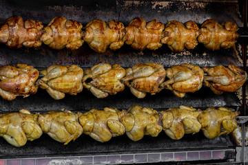 Appetizing juicy grilled chicken on a spit.