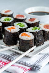 A selection of sushi rolls with salmon, tuna, cucumber and soy sauce dip.