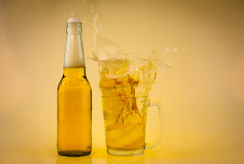 Bottle and Glass of cool beer with foam, clipping path, bubbles in a drink, on abstract orange background.