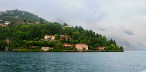 Panoramic view of Como lake with villages and mountains shrouded in clouds. Cernobbio. Italy.