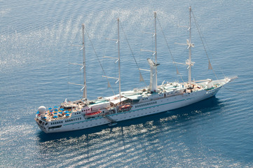 Naklejka premium View of large old-fashioned sailboat moored with bare masts floating on the Mediterranean Sea off Santorini, Greece