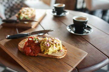 Single piece of italian baguette with cheese pasta toppings and red tomato sauce served with coffee in cafe