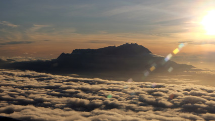 View of the peak of Mount Kinabalu, Sabah, Malaysia, surrounded by sea of clouds, in the morning sun.