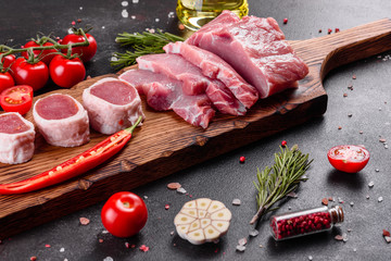 Fresh pieces pork ready to cook on a dark background in the kitchen