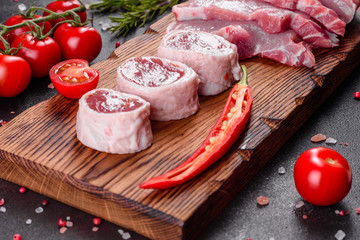 Fresh pieces pork ready to cook on a dark background in the kitchen