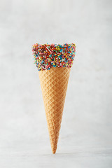 Ice cream cone with chocolate sprinkles on a grey background. Copy space