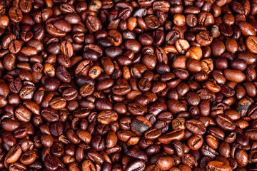 Grains of fresh roasted coffee close-up against a dark background. Coffee beans texture