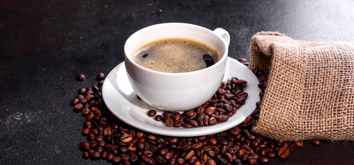 Preparation of aromatic morning coffee. Empty white coffee cup on a dark table