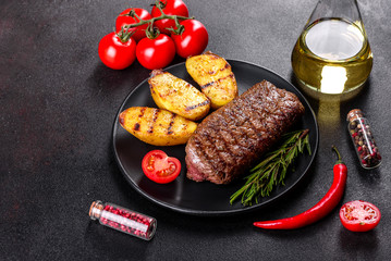 Ribeye steak with potatoes, onions and cherry tomatoes. Juicy steak with flavored butter