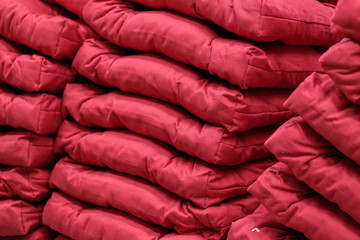 Modern red pillows standing in a stack.