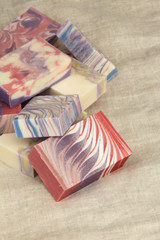 Bars of colourful artisanal handcrafted soap on linen backdrop