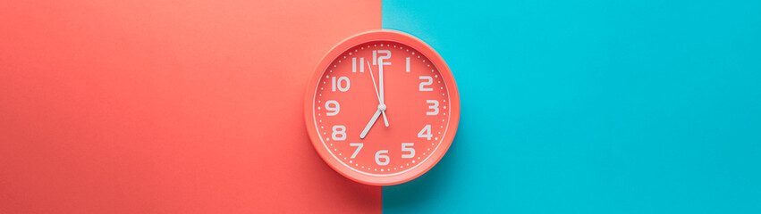 Red clock alarm clock on colored background divided vertically into red and green color web banner:...
