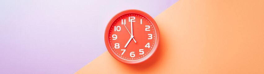 Red clock alarm clock on colored background divided into lilac and beige color web banner: planning...