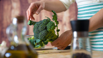 Moments of daily life in Mediterranean cuisine: low angle view of a young female cook cleans...