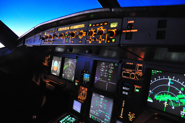 Flight deck of an Airbus A 320 in flight at night taken from the first officer seat - obrazy, fototapety, plakaty