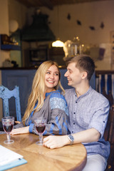 couple in blue clothes having dinner at a restaurant near the blue doors with a view of the city