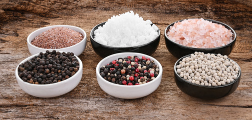 Pepper and color salt on the old wooden