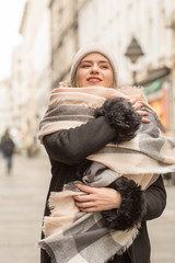 Beautiful young woman in winter autumn outfit walking in the city street