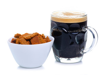White bowl with black bread croutons on white background isolation