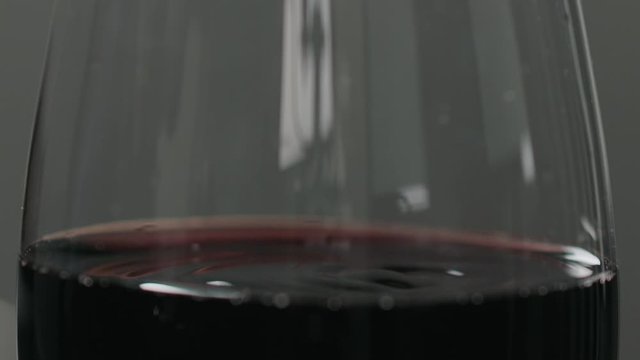 Slow motion pour red wine into wineglass closeup