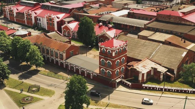 Old manufactory paper mill in a small town. Aerial circular shot