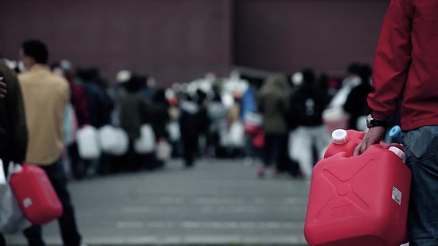 Large queue of civil who wait for the distribution of drinkable water with close-up on an empty containers, after the tsunami on March 11th 2011 near Fukushima