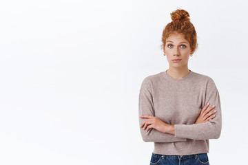 Skeptical redhead caucasian female with curly hair in bun, cross arms over chest in closed pose,...