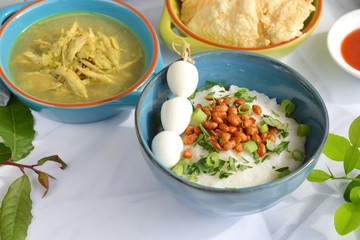 Bubur ayam, Indonesian chicken rice porridge or congee with shredded chicken, fried soy beans, boiled quail egg skewer, celery, scallion, krupuk and emping. 