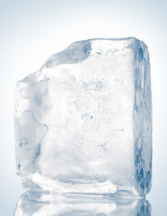 Block of clear ice on reflective surface. Clipping path included.