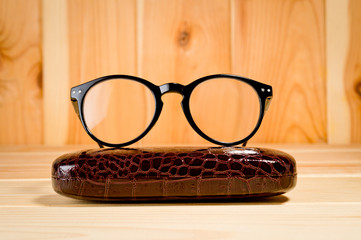 Glasses with a black plastic frame and lenses and case. Background for a healthy vision. Unisex...