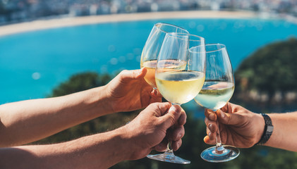 Drink glasses white wine in hands outdoor seascape holidays, romantic couple toast with alcohol, people cheering fun vacation enjoying travel time together friendship love concept congratulations