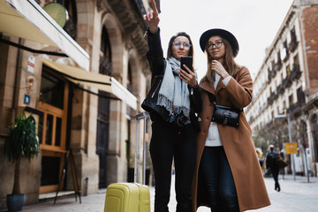  tourist plans trip on internet mobile phone. Travelers using smartphone, hipster travels in Barcelona. weekend concept. online technology