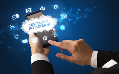 Female hand holding smartphone with SUSTAINABLE DEVELOPMENT inscription, cloud technology concept