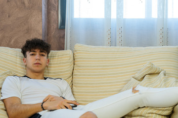 Young man posing on a living room sofa