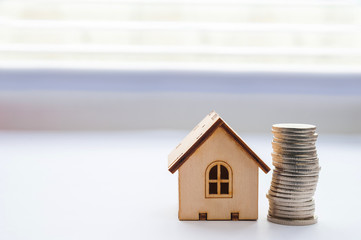 Financial growth concept, real estate tax. Miniature house and a stack of coins. Financial growth concept, real estate tax, buying and selling houses, insurance. Miniature house and a stack of coins.