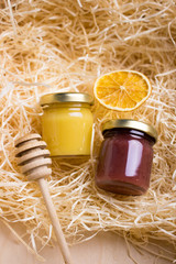 Honey in glass jar on a wooden floor. Background with fresh honey in clear glass jars.