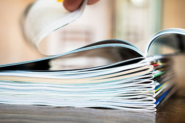 Closeup background of a pile of old magazines with bending pages