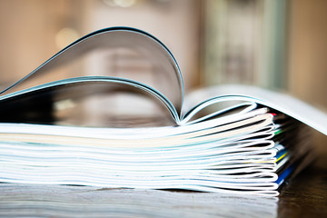 Closeup background of a pile of old magazines with bending pages