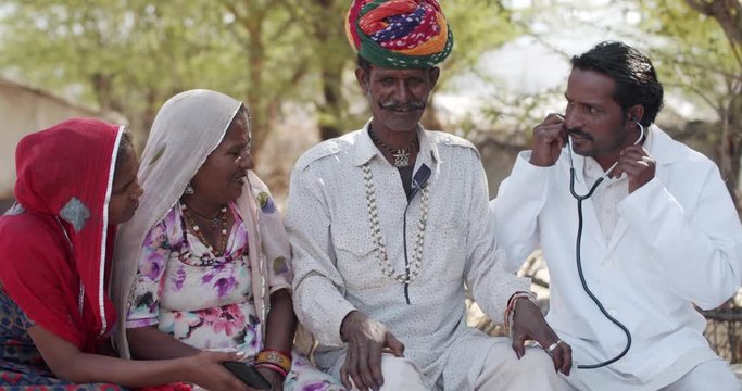 Elderly parents, husband wife, along with their teenage daughter welcome namaste a male doctor to checkup medical consultant for their diseases and sufferings in knees of old age in rural India