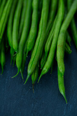 string beans on dark stone background