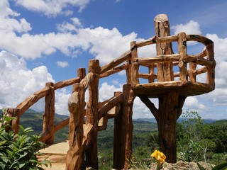 Fototapeta premium Carved wooden stairs in a popular garden, with gorgeous clouds in the skies.