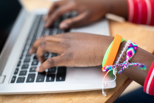 Close Up Of Teenage Girl Wearing Wristbands Typing On Laptop Computer Keyboard