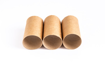 Three toilet paper bushes lie side by side vertically in the center on a white table.