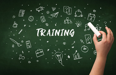 Hand drawing TRAINING inscription with white chalk on blackboard, education concept