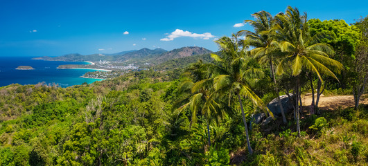 Fototapeta na wymiar Panorama of the tropical island of Phuket with green trees on the foreground and perfect sandy beaches on the horizon, Thailand