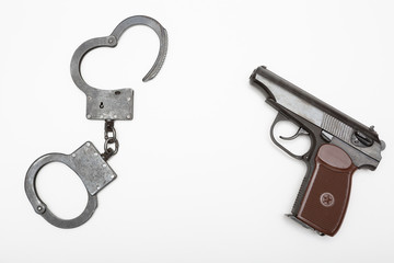 Gun and handcuffs isolated on white background