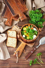Bowl of delicious vegetables soup on wooden table